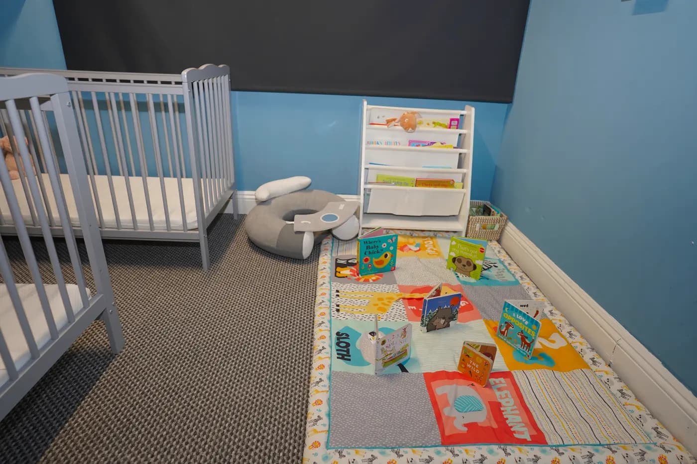Calm baby room with cot, book caddy and sensory mat at Blue Nest Borehamwood