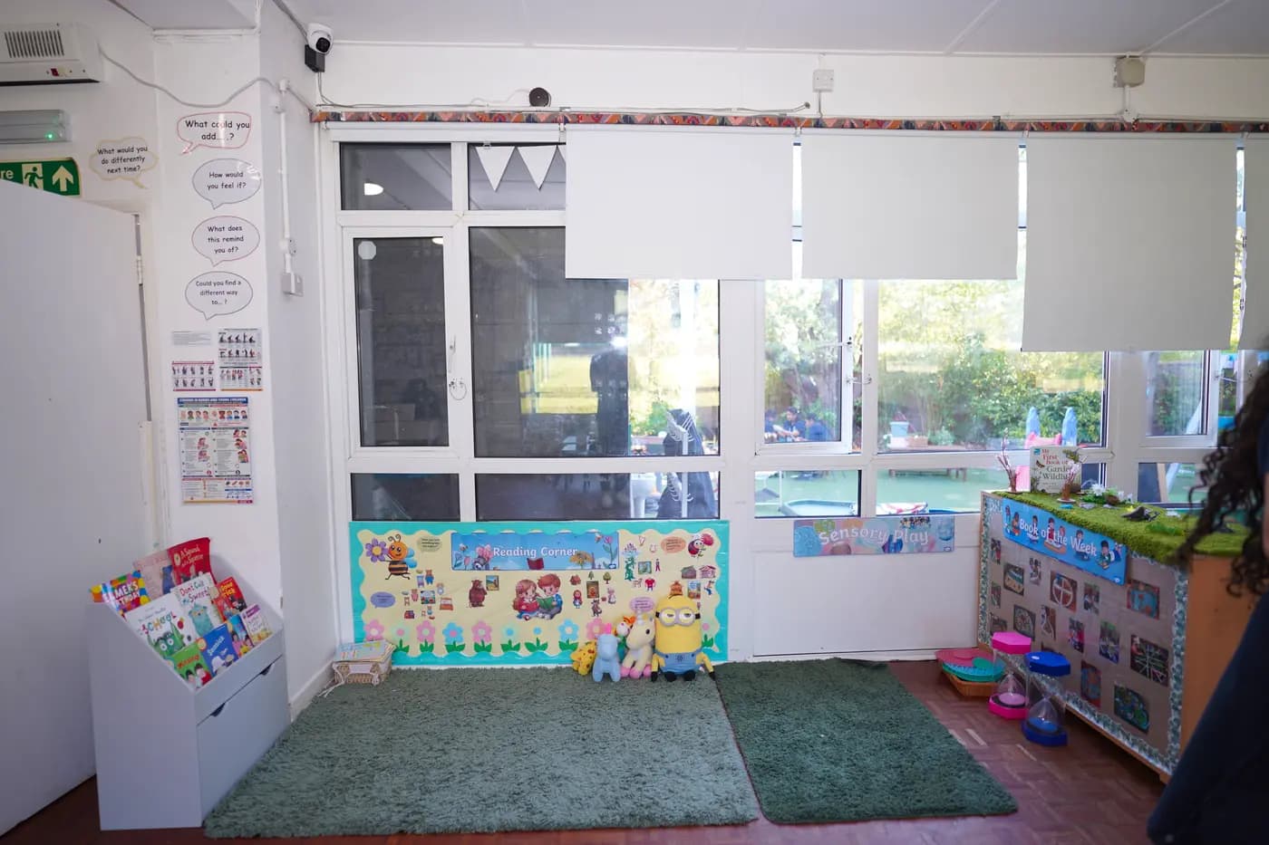 Reading corner with picture-book caddy and sensory-play backdrop at Blue Nest Pinner