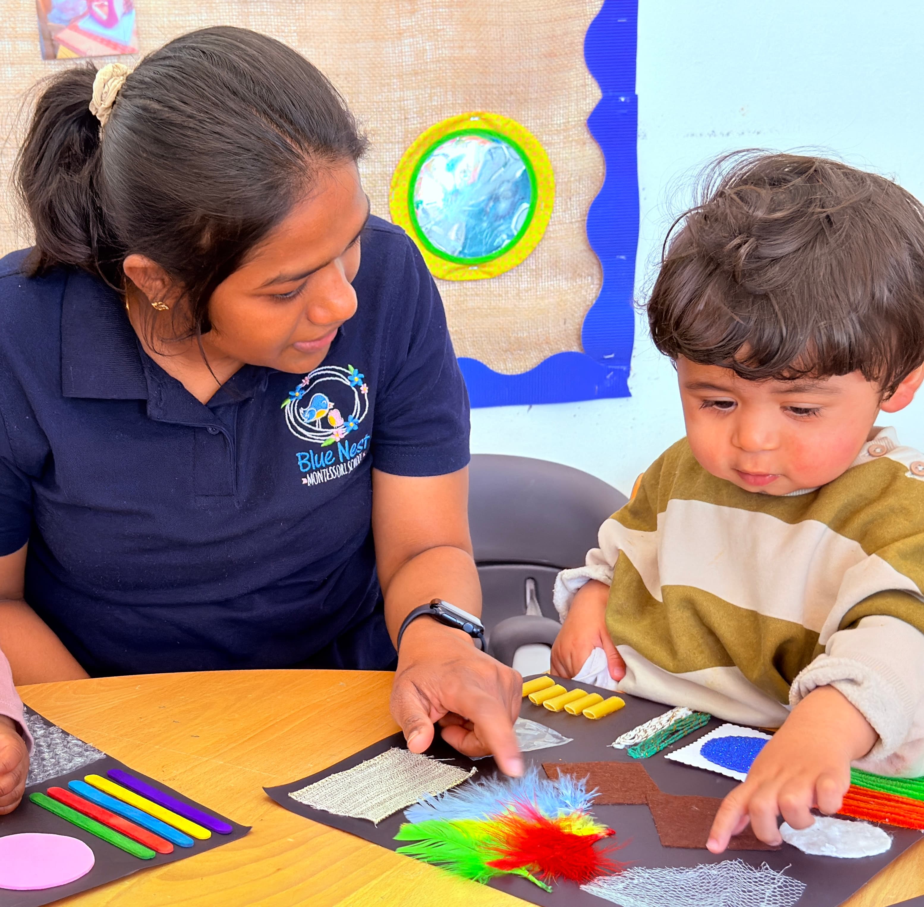 A Blue Nest Montessori educator exploring a sensory craft activity with a child